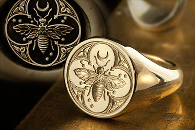 Round signet ring engraved with bee & stars